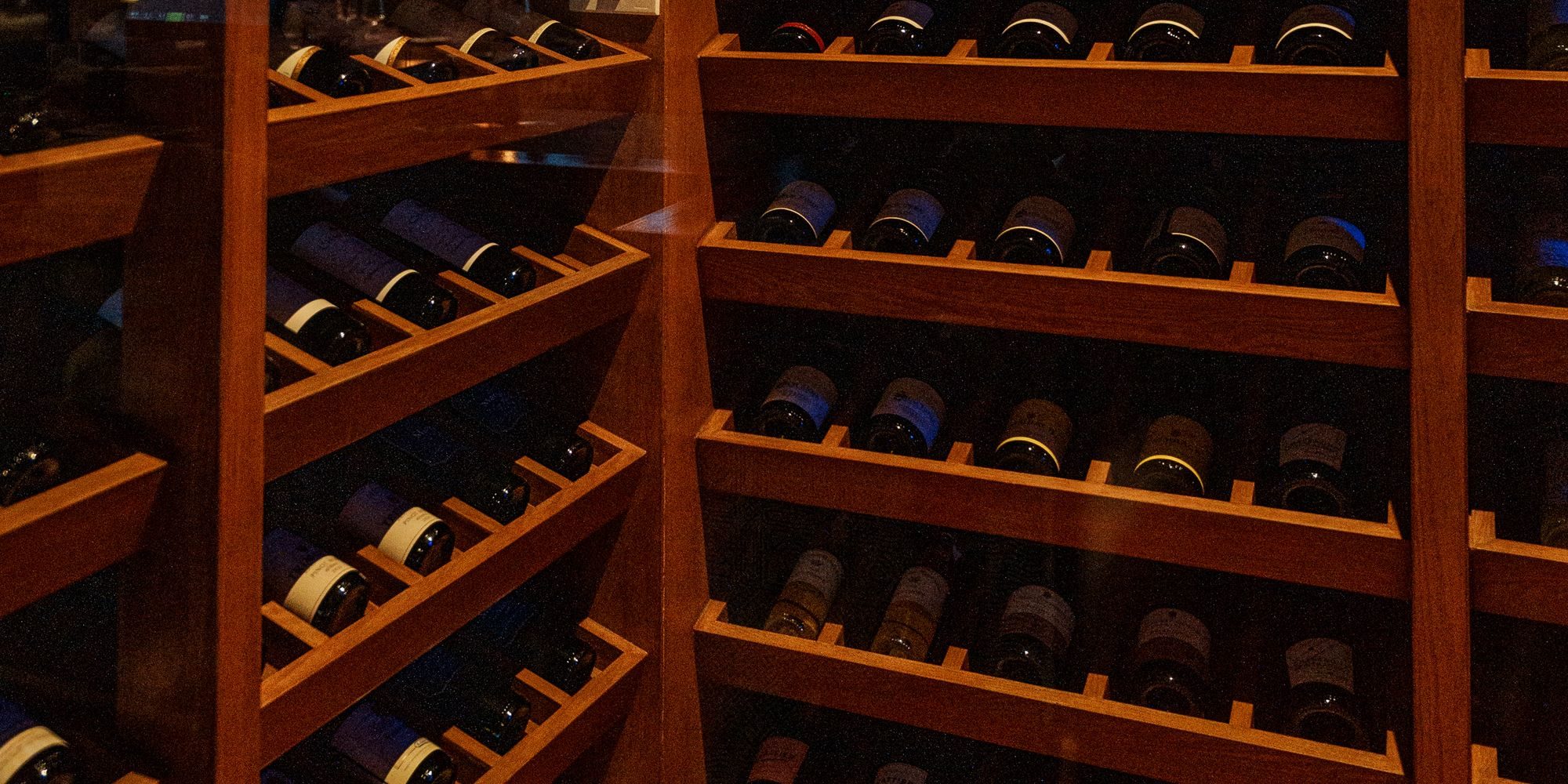 The wine room at ETNA: wooden racks with bottles behind a glass wall