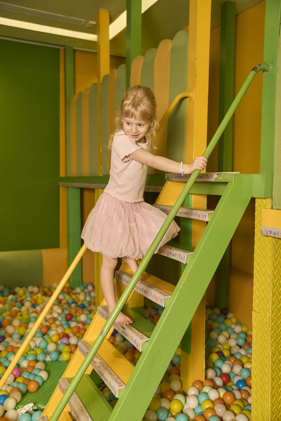 A girl climbing the ladder to the slide in the ETNA kids playroom