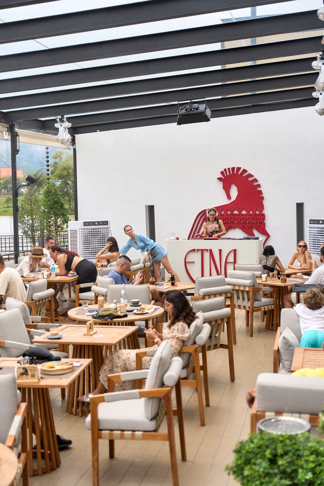 The ETNA terrace full of guests under the red horse