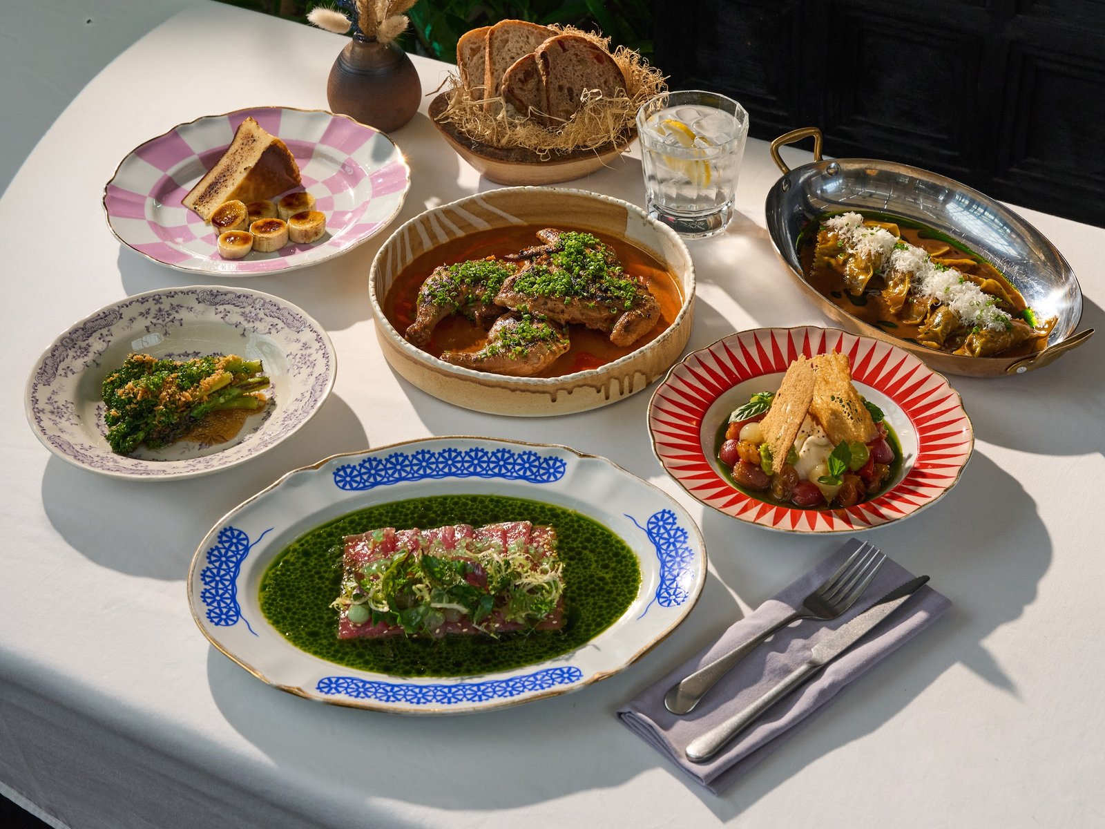 The ETNA table: tuna crudo, broccolini, baby chicken diavola, duck leg ravioli and cheesecake